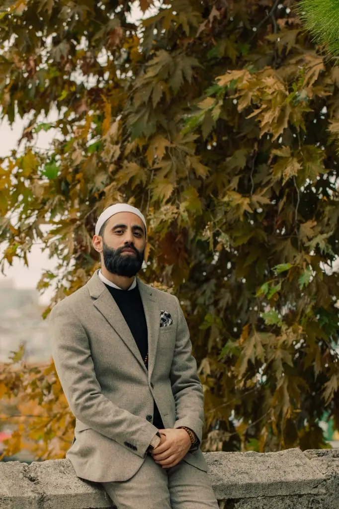 Dr. Ahmad Deeb seated outdoors under autumn leaves